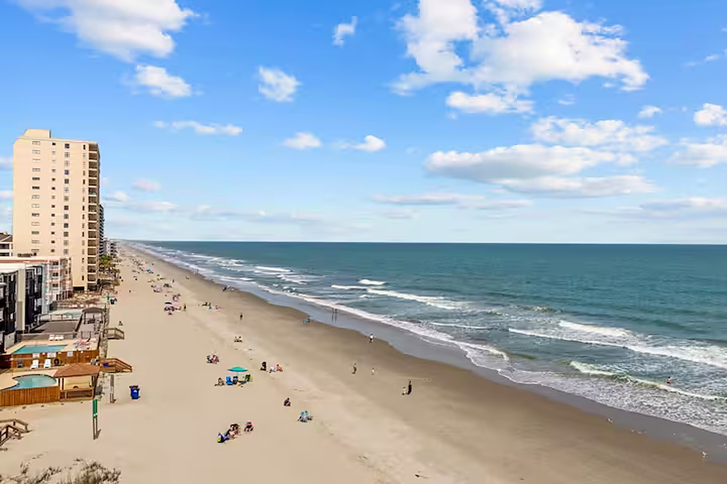 Wide stretch of sand and surf along Garden City Beach seen from above