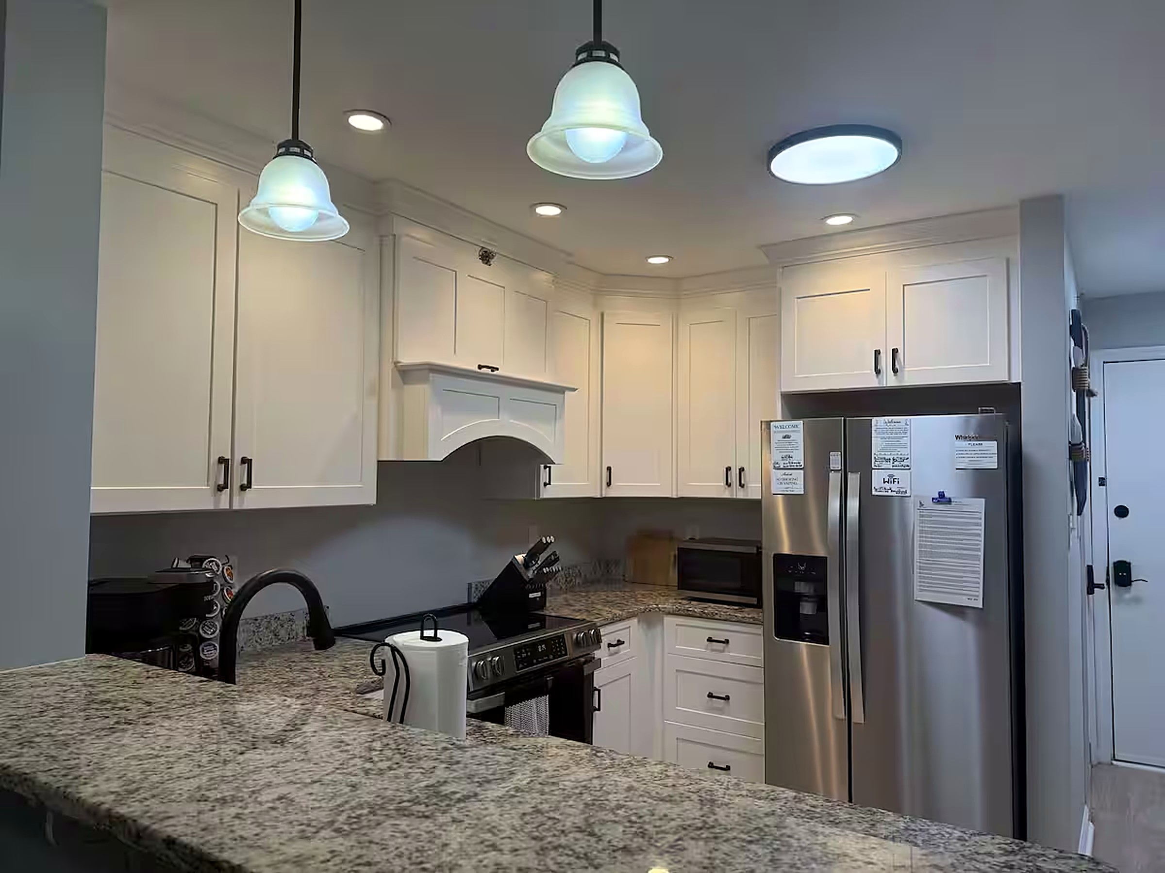 Renovated kitchen with white shaker cabinets, granite counters, stainless appliances and a Keurig coffee bar