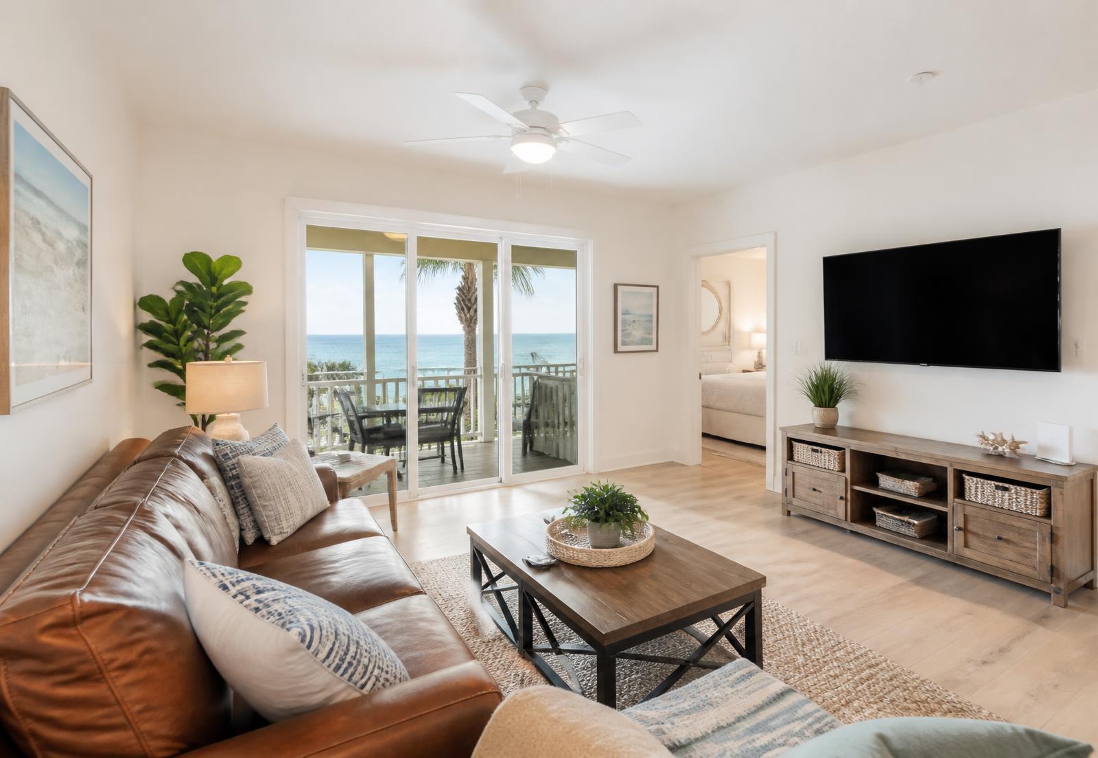 Renovated living room with leather sofa and sliding doors to the ocean-view porch